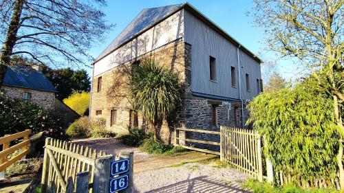 an old brick building with a sign in front of it at Chambre d'hôte en Gîte - Moulin de la Houssaie - Brocéliande in Guer
