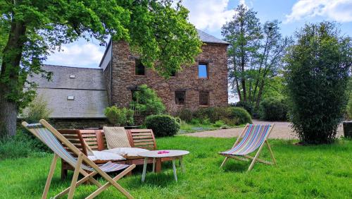 a group of chairs and a table in the grass at Chambre d'hôte en Gîte - Moulin de la Houssaie - Brocéliande in Guer