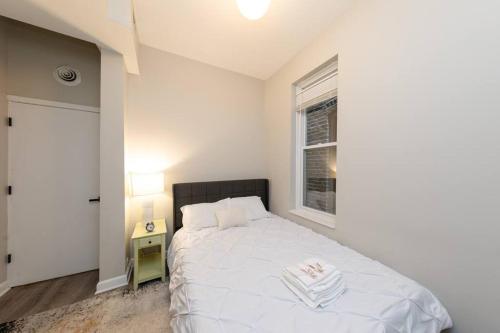 a bedroom with a white bed and a window at The Secret West Loop Oasis in Chicago