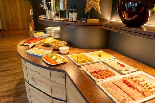 a buffet with many different types of food on a counter at Landhotel Lebensart in Xanten