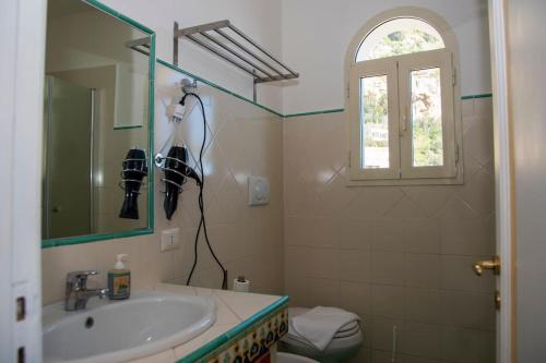 bagno con lavandino, servizi igienici e finestra di M'incanto a Positano
