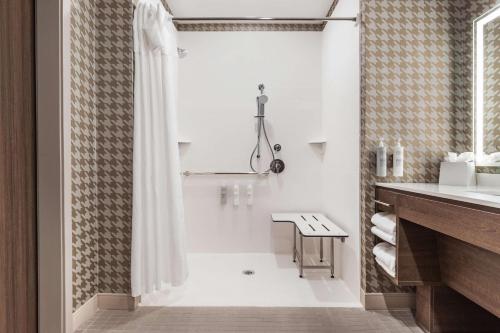 Home2 Suites By Hilton Cedar Rapids Westdale في سيدار رابيدز: حمام أبيض مع دش ومغسلة