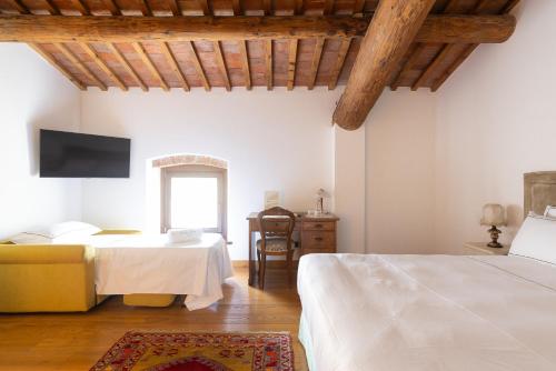 - une chambre avec 2 lits, une table et une télévision dans l'établissement VerdeOlivo 1876, à Mezzane di Sotto