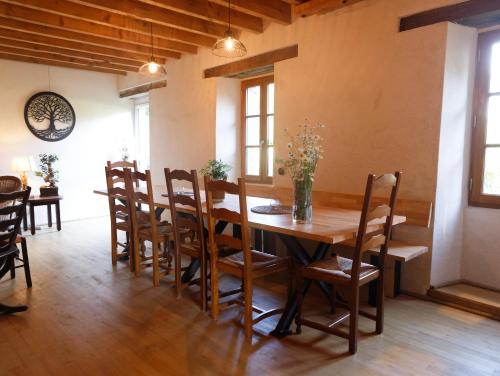 a dining room with a wooden table and chairs at Chambre d'hôte en Gîte - Moulin de la Houssaie - Brocéliande in Guer