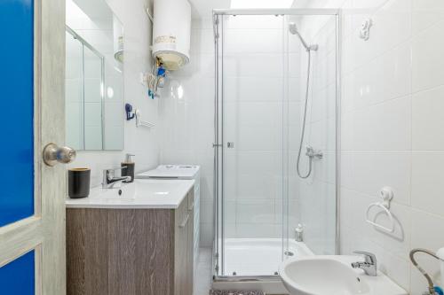 une salle de bain blanche avec une douche et un lavabo dans l'établissement Andrea's Home, à San Bartolomé