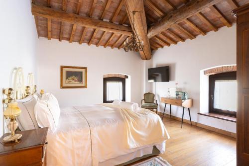 - une chambre avec un lit blanc et un bureau dans l'établissement VerdeOlivo 1876, à Mezzane di Sotto