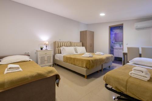 a hotel room with two beds with towels on them at Tinas Village Free Transport from/to the airport in Spáta