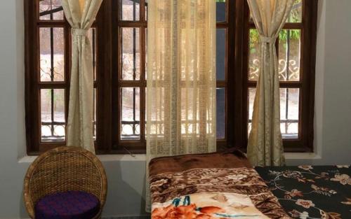 1 dormitorio con ventana, cama y silla en Nardelna Homestay by StayApart, en Māngwa