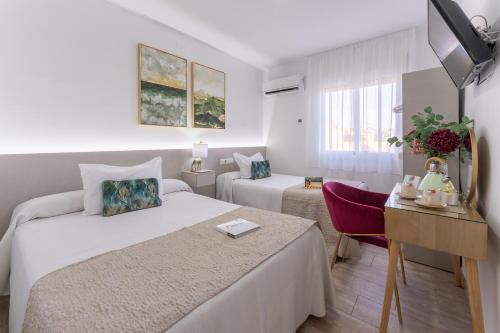a hotel room with two beds and a table with a chair at Urban Rooms B&R in Málaga