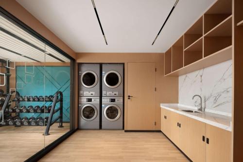 a laundry room with two washer and dryer at Hilton Garden Inn Jiangmen Xinhui in Jiangmen