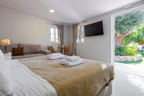 a bedroom with a bed with two towels on it at Tinas Village Free Transport from/to the airport in Spáta