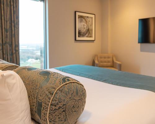 a hotel room with a bed and a window at Hotel La Tour in Milton Keynes