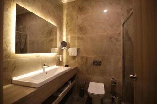 bagno con lavandino, servizi igienici e specchio di Hotel Excellence Inn a Ankara