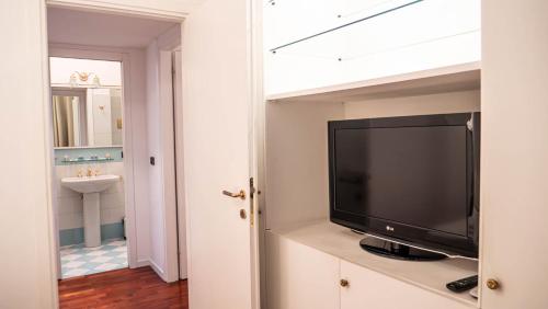 a flat screen tv sitting on a cabinet in a bathroom at APPARTAMENTO Superhouse PIAZZA DUOMO AREA in Milan