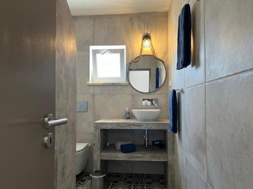 uma casa de banho com um lavatório e um espelho em Quinta Samor em Aljezur