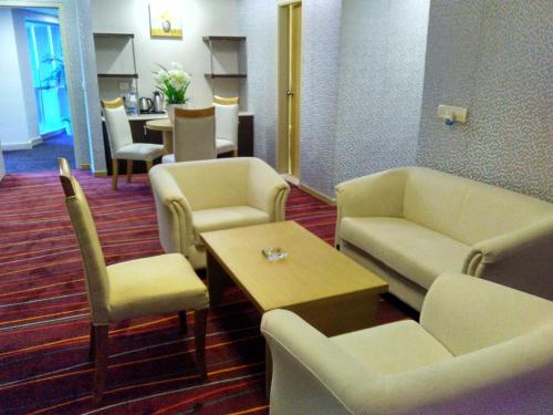 a waiting room with couches and a table and chairs at Maha Bodhi Hotel.Resort.Convention Centre in Bodh Gaya