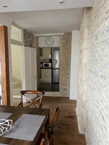 une cuisine et une salle à manger avec une table et des chaises dans l'établissement Appartement 3 Pièces Bord de mer Place du 6 Juin, à Arromanches-les-Bains