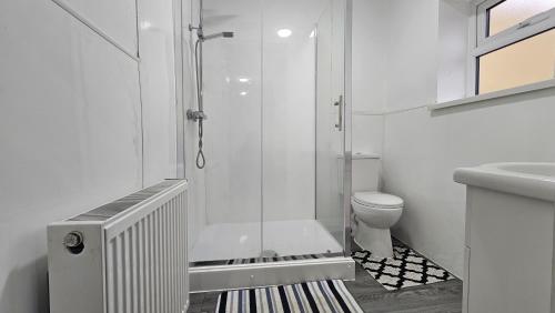 a white bathroom with a shower and a toilet at Double Bedroom with private bathroom and shared kitchen in Oldbury