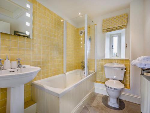 a bathroom with a tub and a toilet and a sink at 1 Bed in Cirencester 57684 in Kemble
