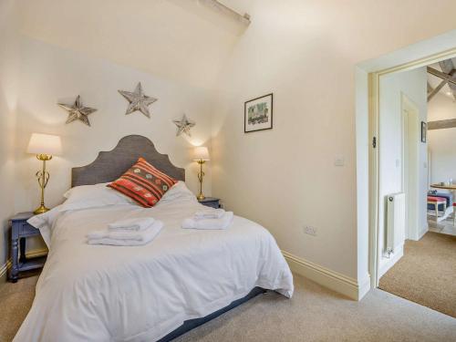 a bedroom with a white bed with stars on the wall at 1 Bed in Cirencester 57684 in Kemble