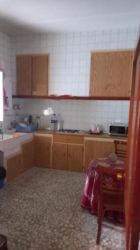 uma cozinha com armários de madeira e uma mesa em Casa Custodia em Mota del Cuervo