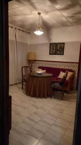 uma sala de estar com uma mesa e um sofá em Casa Custodia em Mota del Cuervo