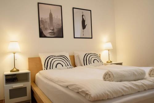 een slaapkamer met een groot wit bed met twee lampen bij Peony Káldy Apartman Free Garage under the house in Boedapest