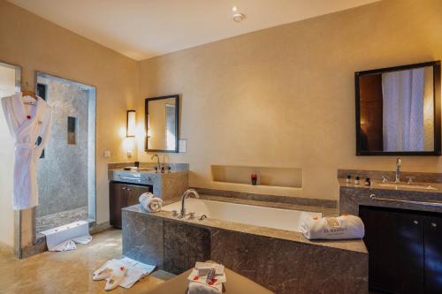 a large bathroom with a tub and a sink at Al Maaden Villa Hotel & Spa in Marrakesh