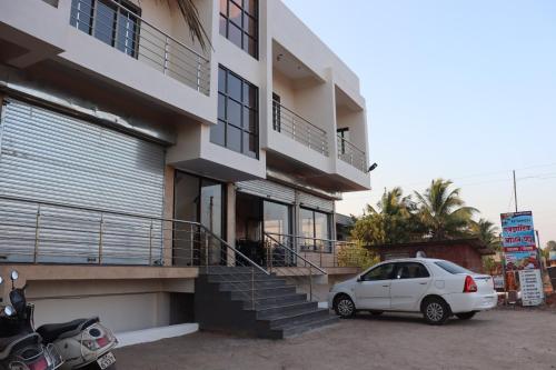 a white car parked in front of a building at Exotic Oceanview in Malvan