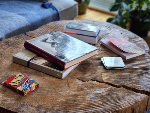a group of books on a wooden table at Chalet NABU L'Ours - Rivière - Billard in Saint-Alexis-des-Monts