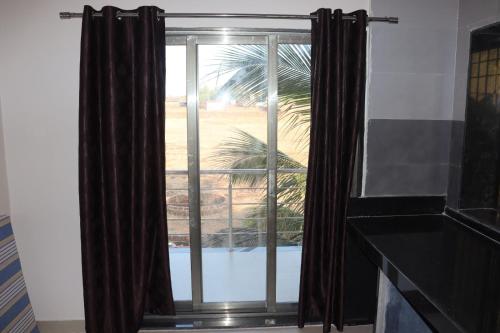 a window with a view of a palm tree at Exotic Oceanview in Malvan