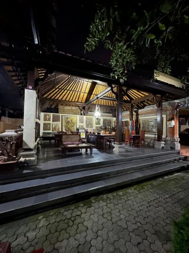 een paviljoen met tafels en stoelen in een gebouw bij Nirvana Pension in Ubud