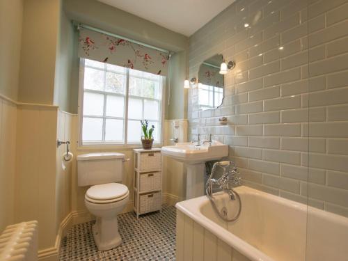 a bathroom with a toilet and a tub and a sink at 3 Bed in Shap 74159 in Shap