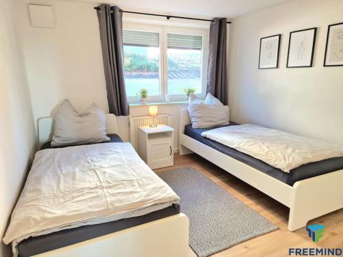 a bedroom with two beds and a window at frisch modernisiertes Apartment in Altdorf