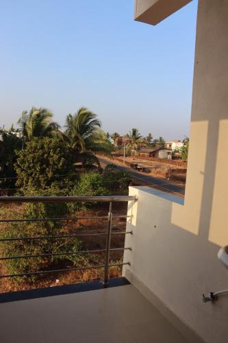 a balcony with a view of the desert and palm trees at Exotic Oceanview in Malvan