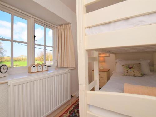 um quarto com um beliche e uma janela em 2 Bed in Brixham 74200 em Churston Ferrers