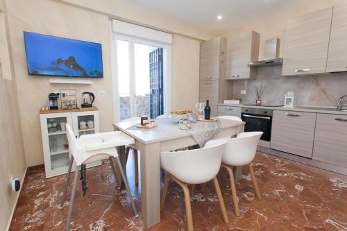 a kitchen with a table and chairs and a sink at Luxury house Il tramonto in Anzio