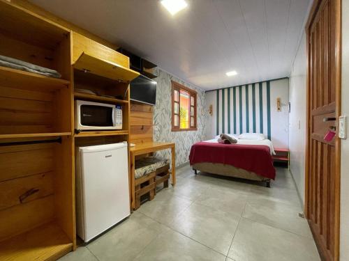 a small room with a bed and a small kitchen at Moçamba LODGE Contêiner in Florianópolis