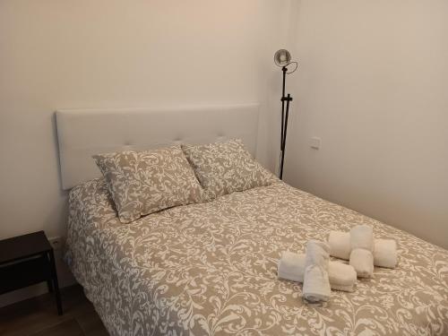 1 dormitorio con 1 cama con toallas en Puerta de Hierro Apartments, en Madrid
