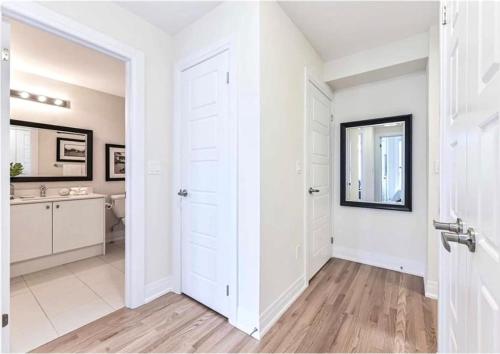 een witte badkamer met een witte deur en een wastafel bij Luxe Toronto Townhome, Rooftop Terrace, Parking in Toronto
