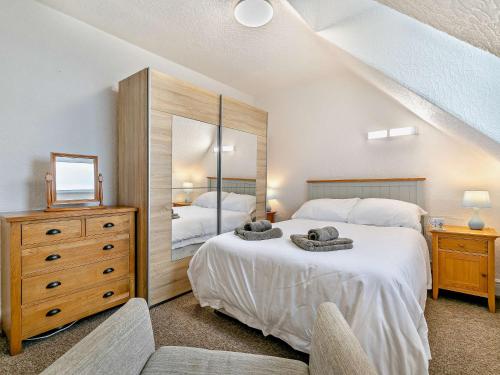 a bedroom with two beds and a large mirror at 2 Bed in Woolacombe 76350 in Woolacombe