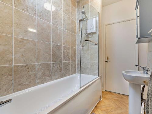 a bathroom with a bath tub and a sink at 2 Bed in Woolacombe 76350 in Woolacombe
