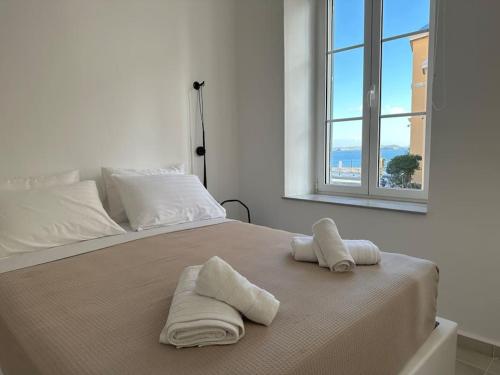 a bedroom with a bed with two towels on it at Fouli,Syros Apartment,Ermoupoli in Ermoupoli