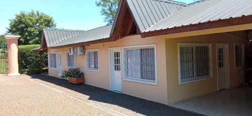 a small yellow house with a white door and windows at El Olimpo in Wanda