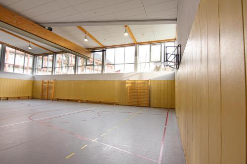 an empty basketball court in a building with windows at Green Night Hotel in Falkenstein