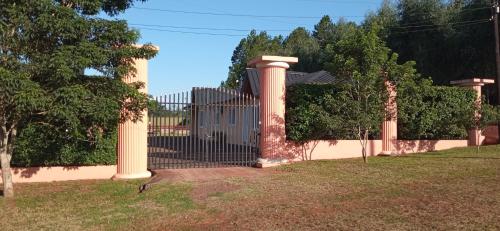a gate with pillars in a yard with trees at El Olimpo in Wanda