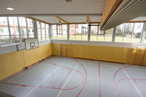an empty gym with a basketball court in a building at Green Night Hotel in Falkenstein
