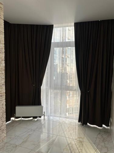 a room with black curtains and a large window at Arcadia Adelina in Odesa