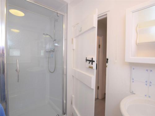 a white bathroom with a shower and a toilet at 3 Bed in Salcombe 75138 in Bigbury