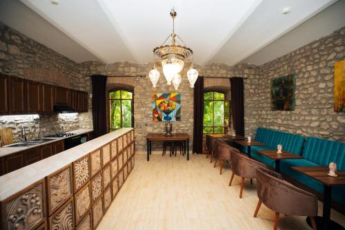 a restaurant with tables and chairs and a chandelier at Art Hotel by ABAD Guest in Sheki